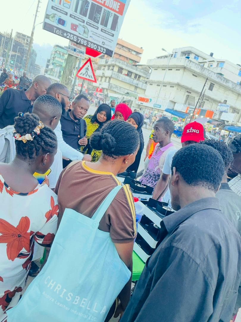 A crowd gathered around a Gastro cookstove display on a busy Tanzanian street