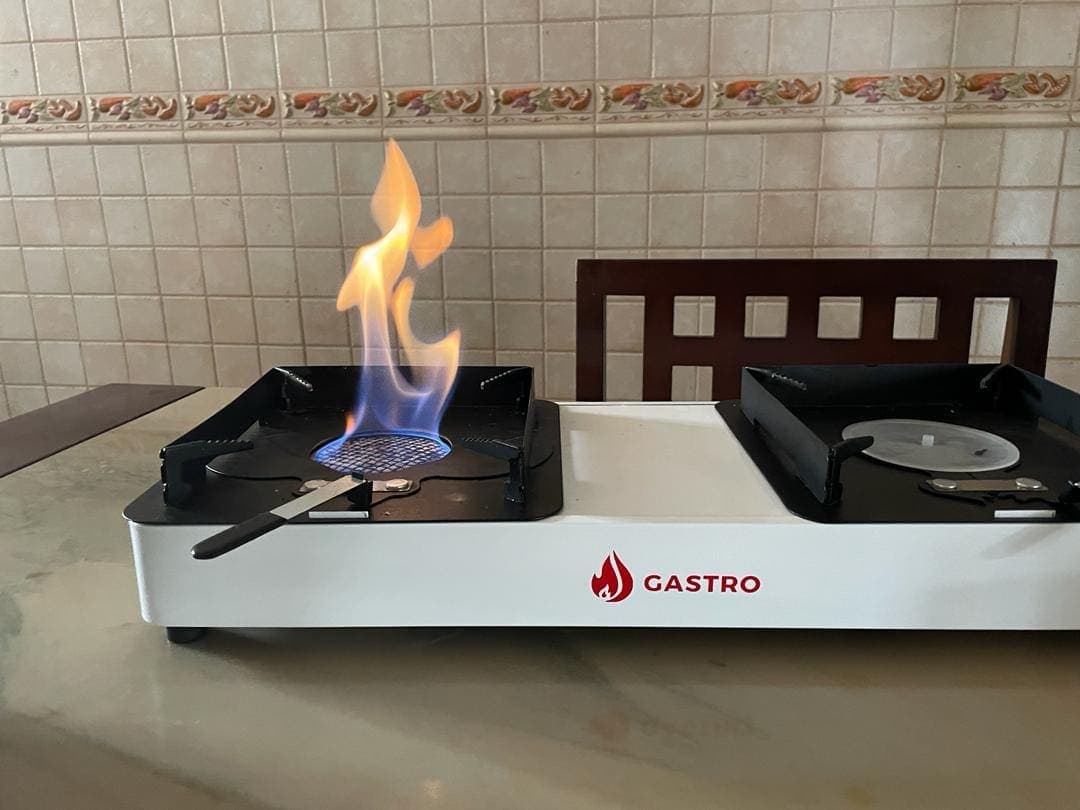 An earlier Gastro double-burner ethanol cookstove with one burner lit
